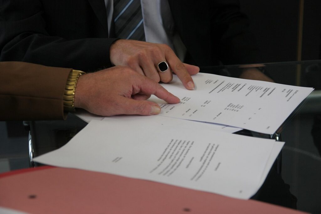 Small business owner reviewing and signing MCA contract at desk
