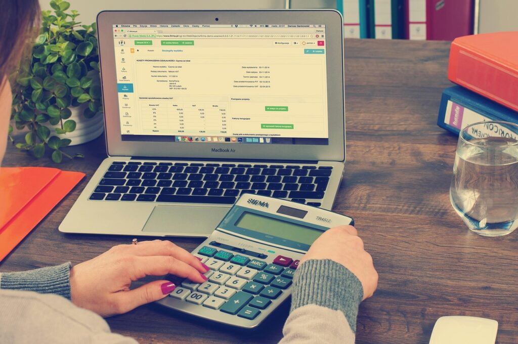 Stack of financial documents and a calculator on a small business owner's desk