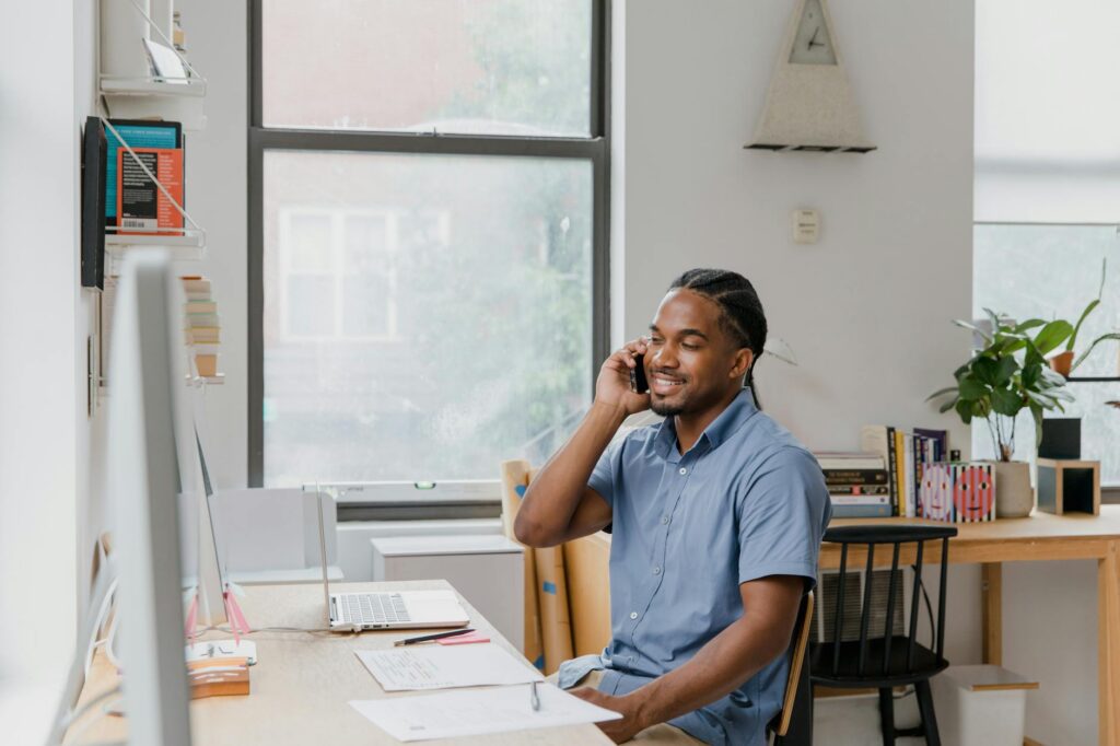 Small business owner on a phone consultation at their desk with a hopeful expression