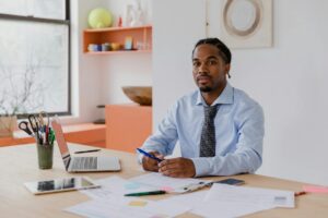 A small business owner drafting a hardship letter at a kitchen table