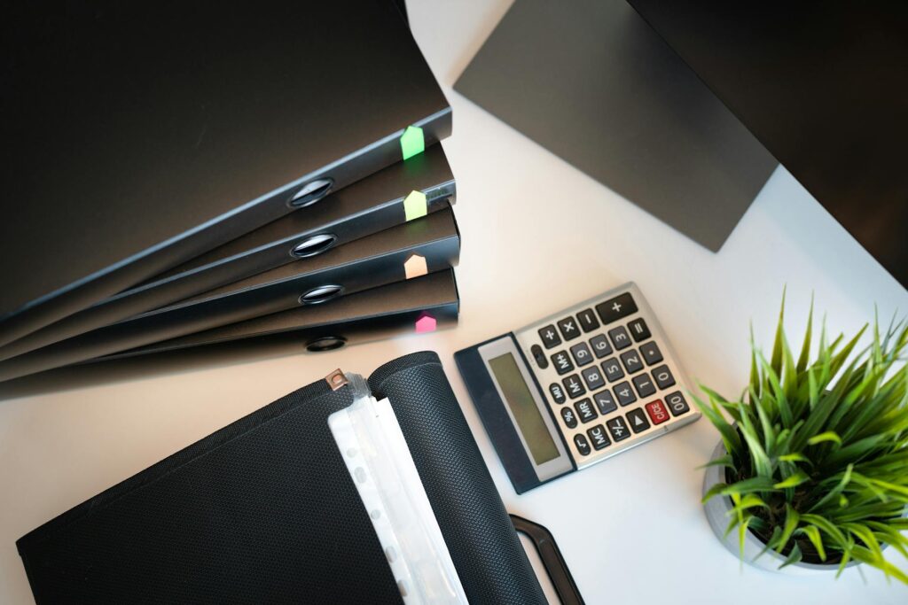 Stack of MCA loan documents accumulating on a contractor's desk