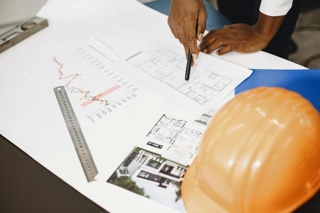 Contractor reviewing invoices and cash flow documents at construction office desk