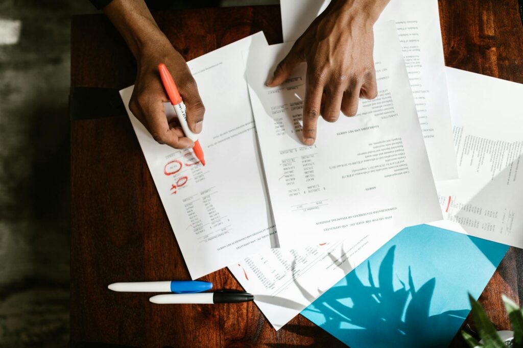 Auto repair shop owner reviewing MCA debt documents at their desk