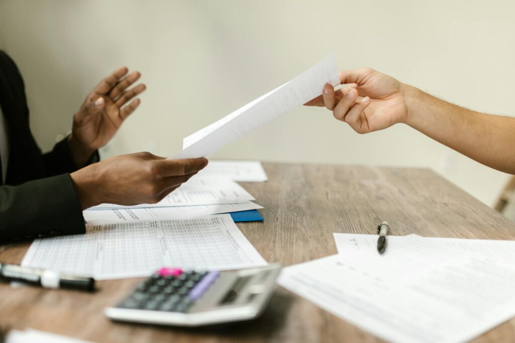 Business negotiation between contractor and MCA funder representative at desk