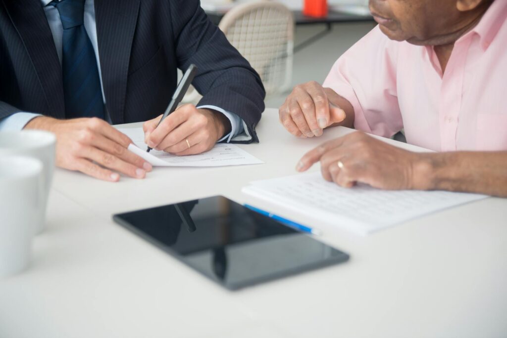 Business advisor and owner negotiating MCA lockbox settlement at conference table