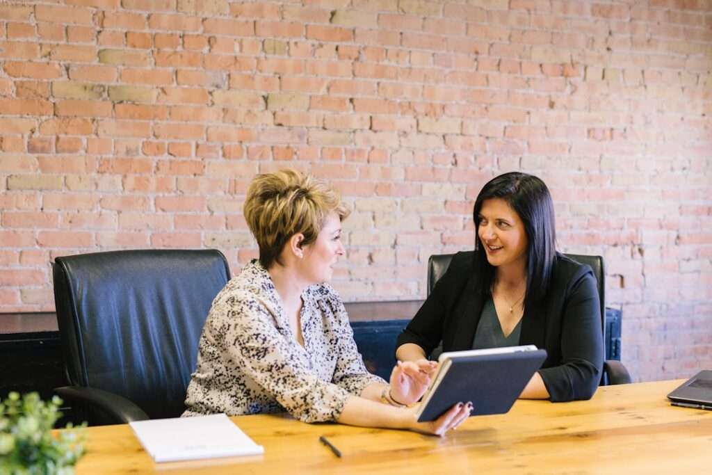 Small business owner and financial advisor reviewing documents across a table