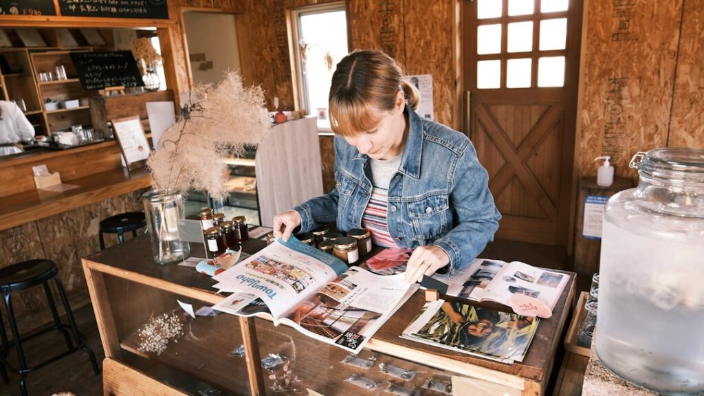Independent retail boutique owner reviewing MCA debt paperwork at store desk