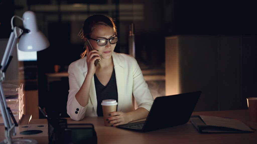 Business owner under stress reviewing MCA contract documents late at night