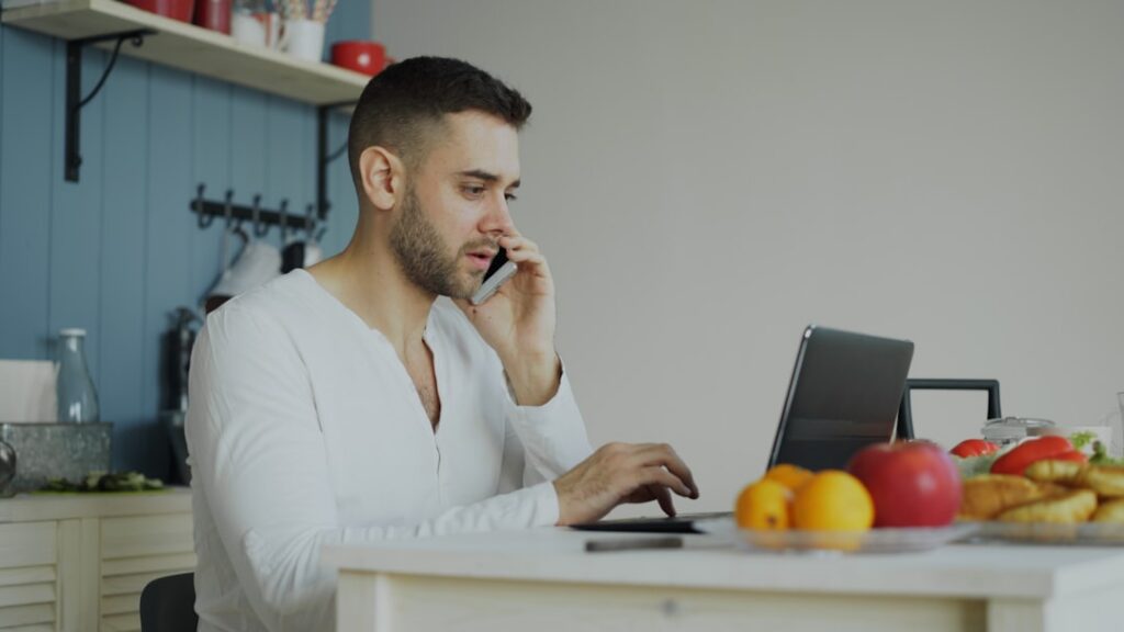 Business owner reviewing MCA payment statements at kitchen table late at night