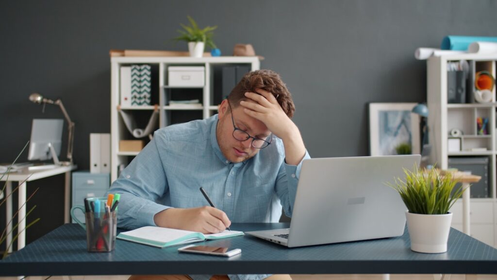 Small business owner reviewing MCA settlement paperwork at desk