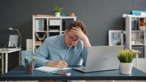 Small business owner reviewing MCA settlement paperwork at desk