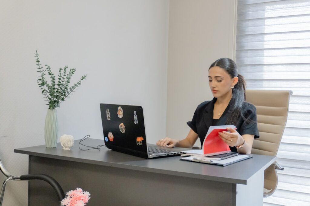 Landscaping business owner reviewing MCA debt paperwork at office desk