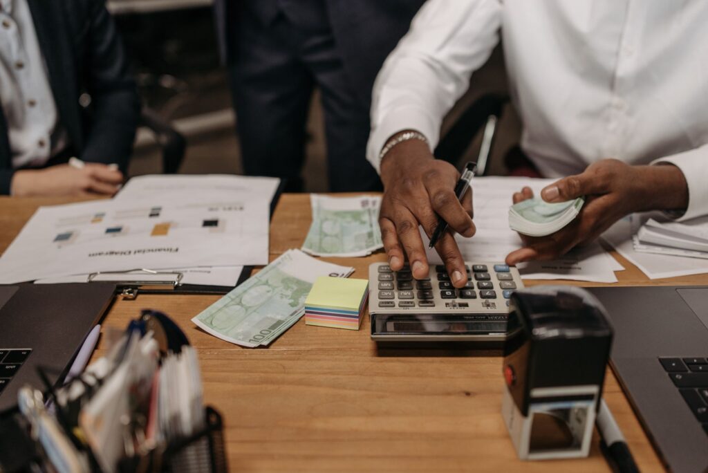 MCA funding paperwork and cash flow calculations at a small business desk