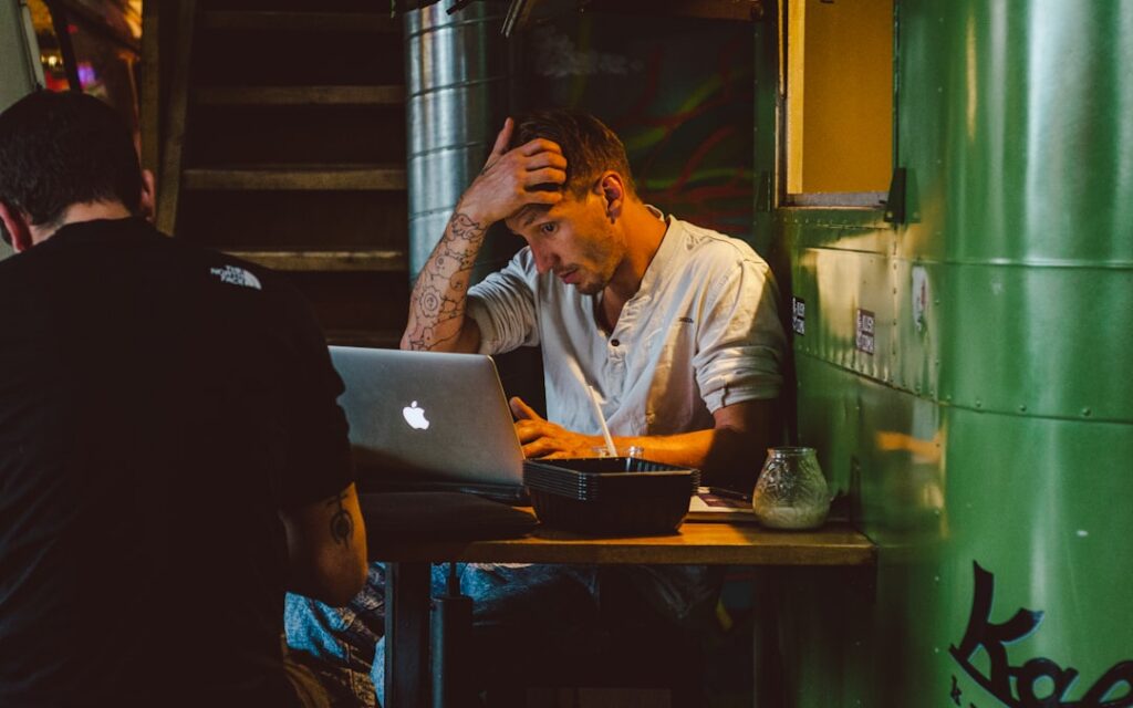 Franchise owner reviewing MCA debt paperwork at desk late at night