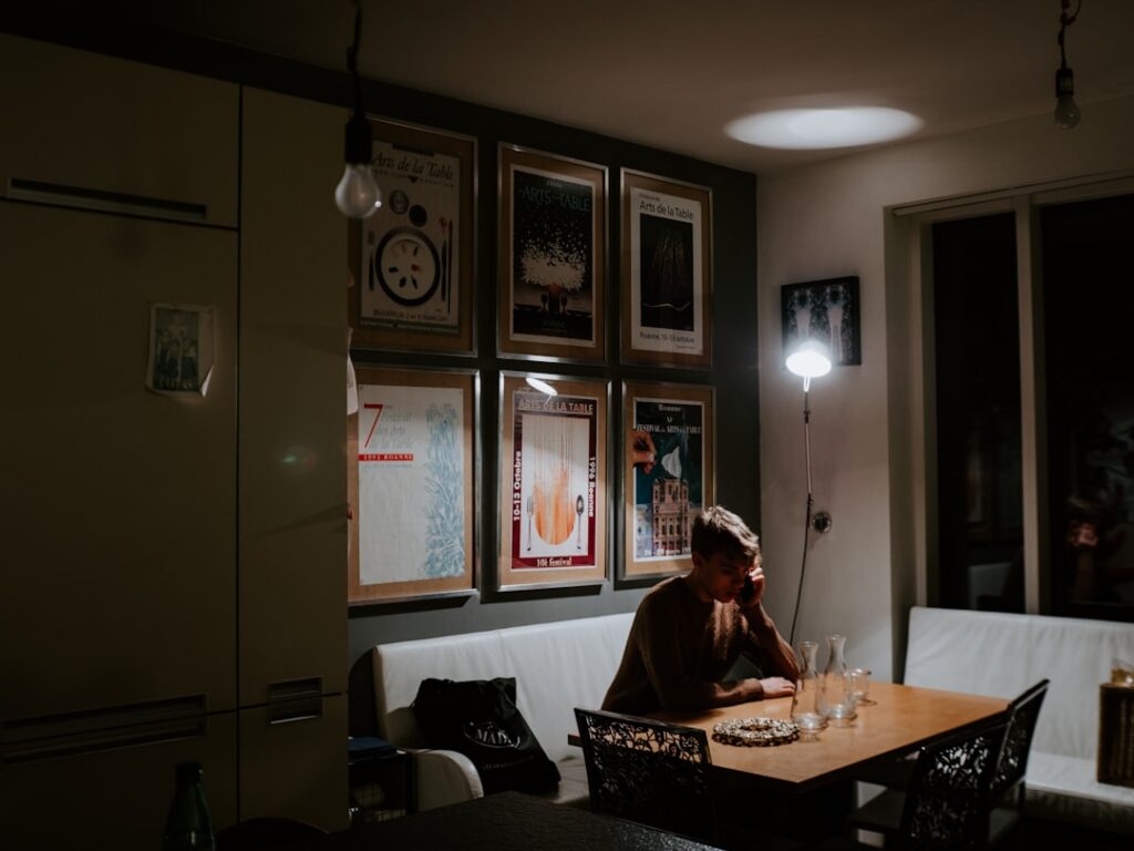 Small business owner at home desk late at night reviewing bills and financial statements
