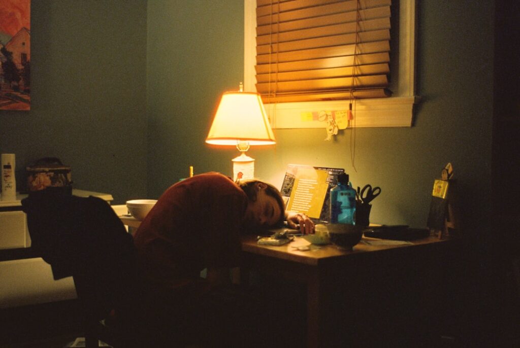 Small business owner reviewing MCA contracts and financial documents late at night