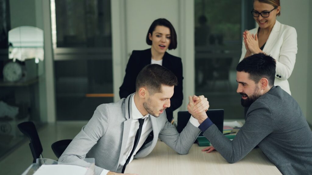 Business handshake across small office desk after signing settlement agreement