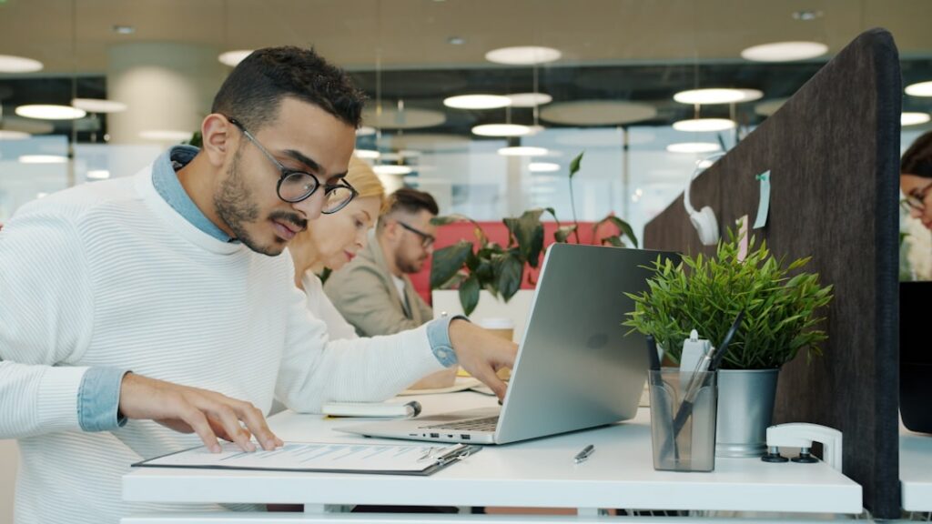 Small business owner on a phone call looking focused and confident at their desk with financial documents