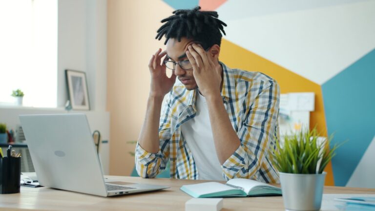 Small business owner reviewing MCA debt documents and financial statements