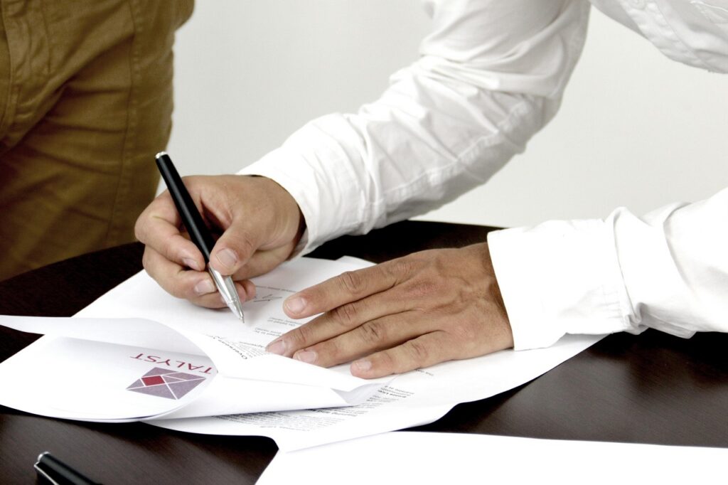 Business owner and advisor reviewing a settlement agreement across a desk