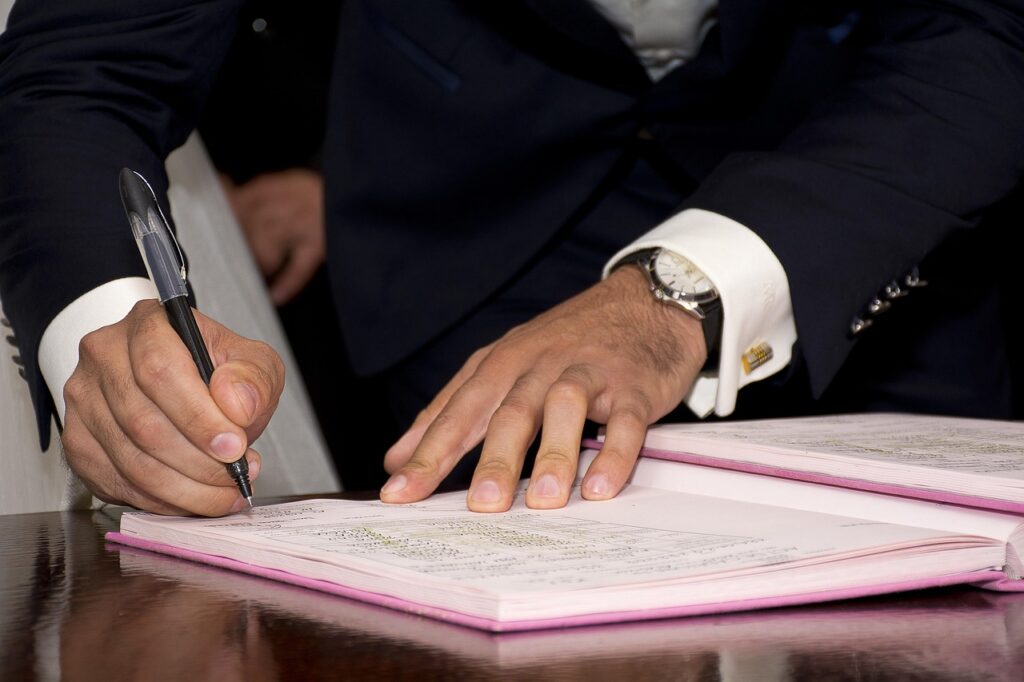 Couple signing a wedding venue contract while making a deposit payment