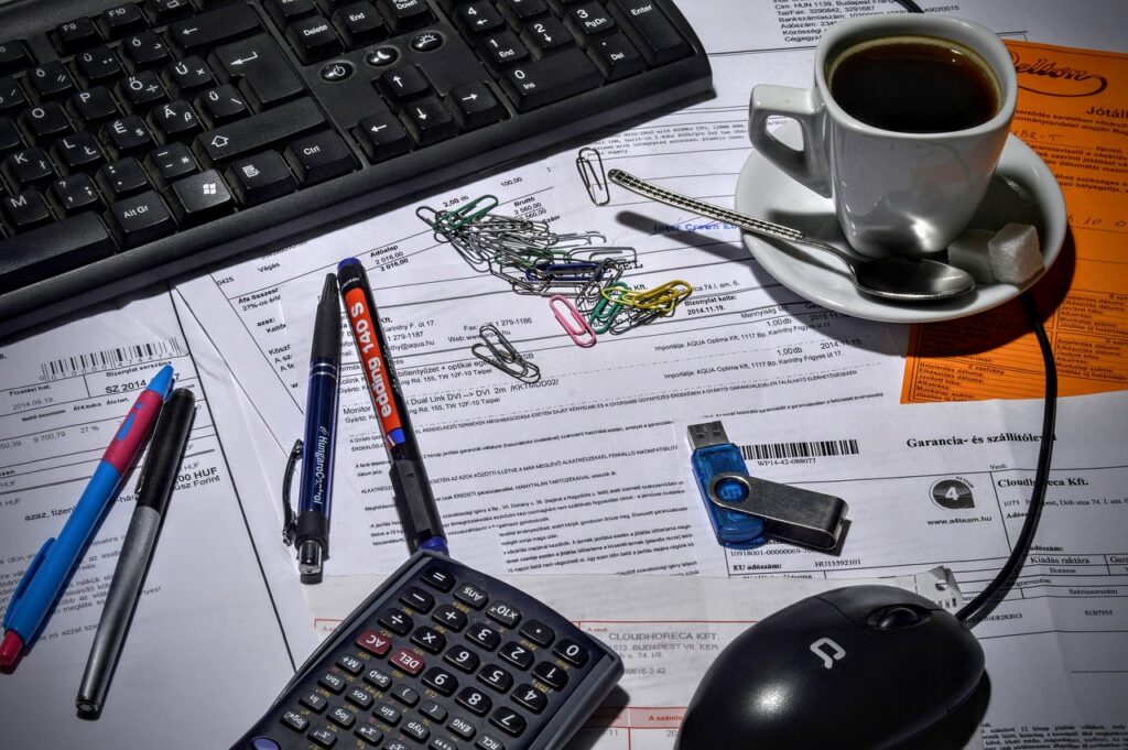 Business owner weighing a financial decision at a desk with documents spread out