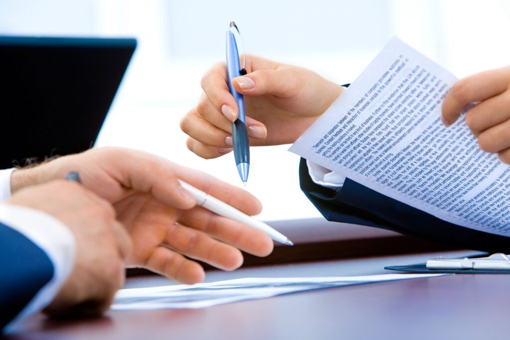 Bank loan officer reviewing SBA loan paperwork with a small business owner