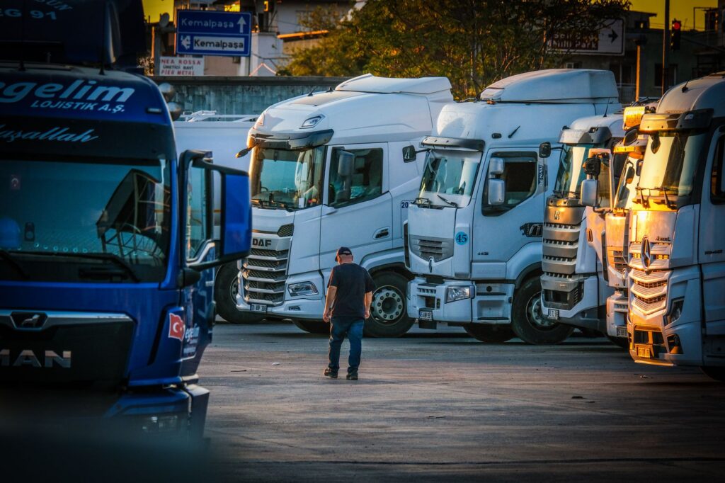 Owner-operator truck driver checking paperwork and phone at a truck stop