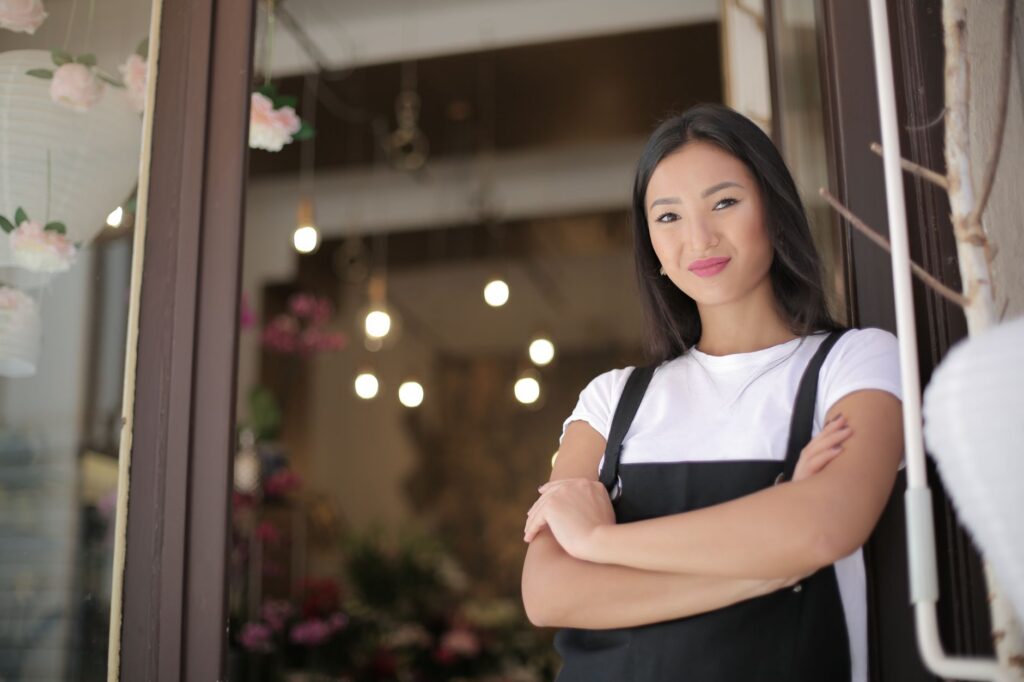 Confident small business owner standing in the doorway of their shop