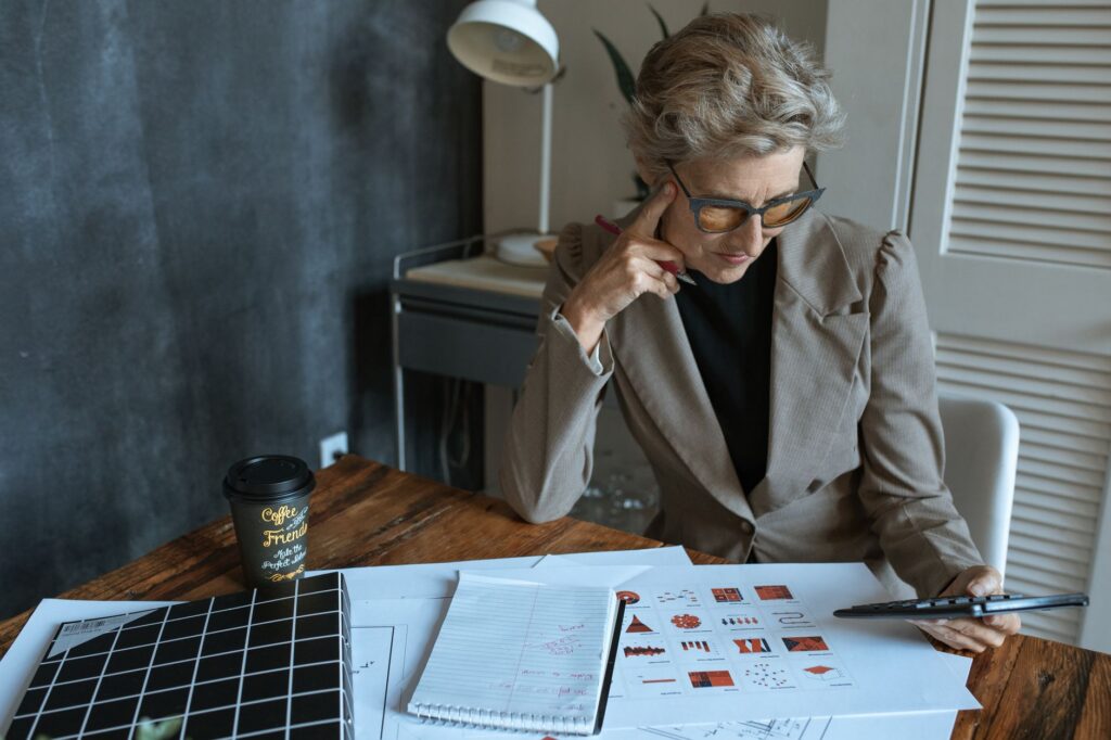 Business owner organizing multiple financing statements on a table