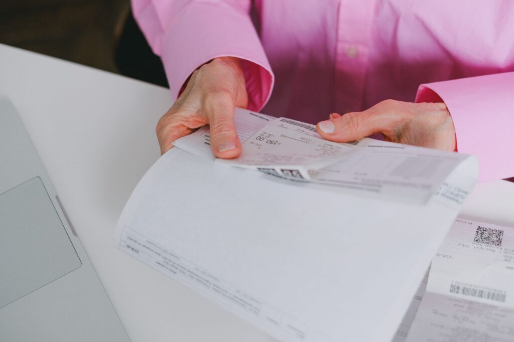 Stressed property manager reviewing multiple bank account statements at a desk