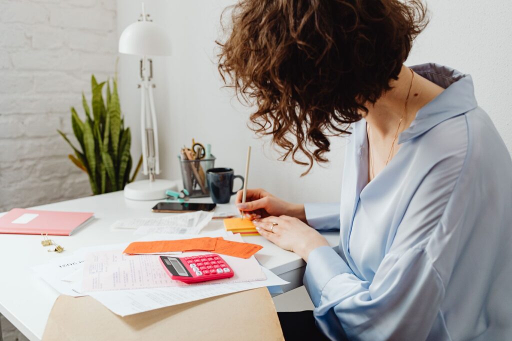 Business owner calculating finances with a retirement account statement on the desk