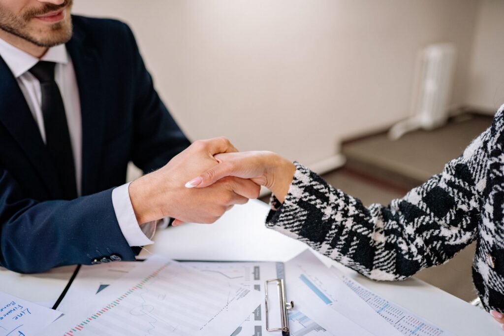Handshake over a signed settlement agreement at a small business office