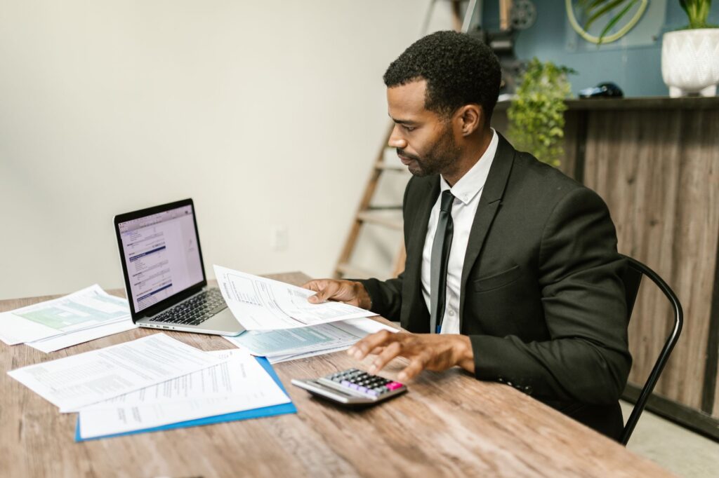 Small business owner reviewing bank statements and daily debits late at night