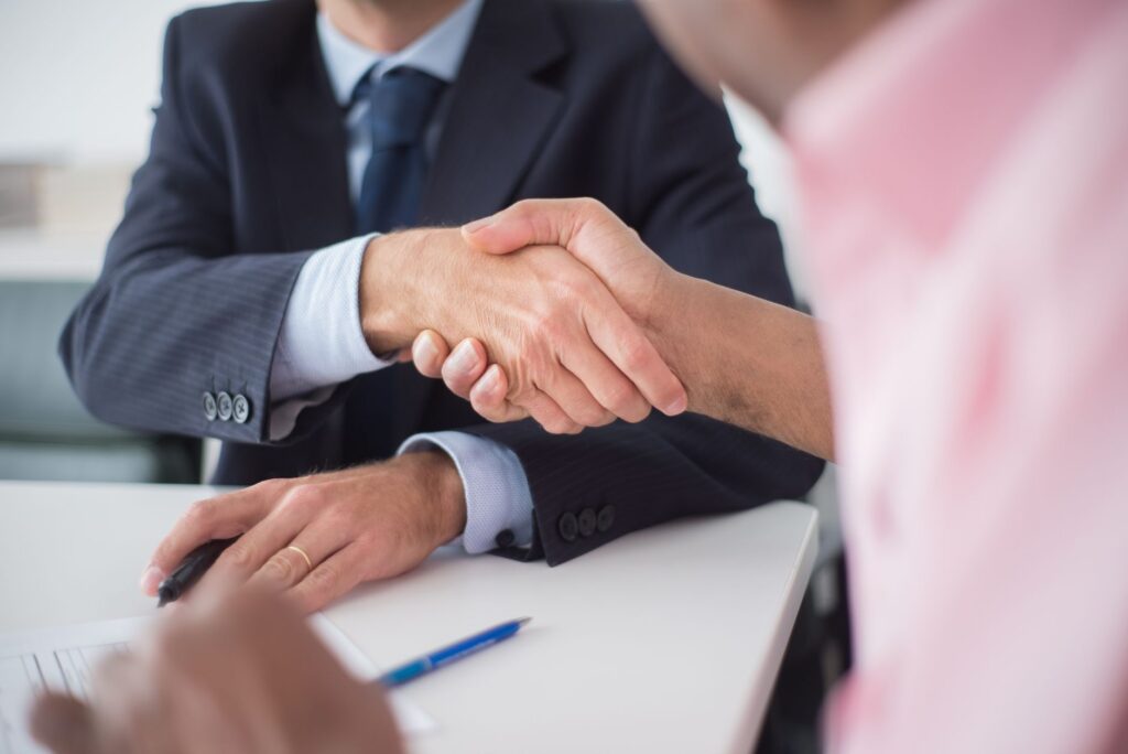 Business owner and advisor shaking hands after a debt settlement negotiation
