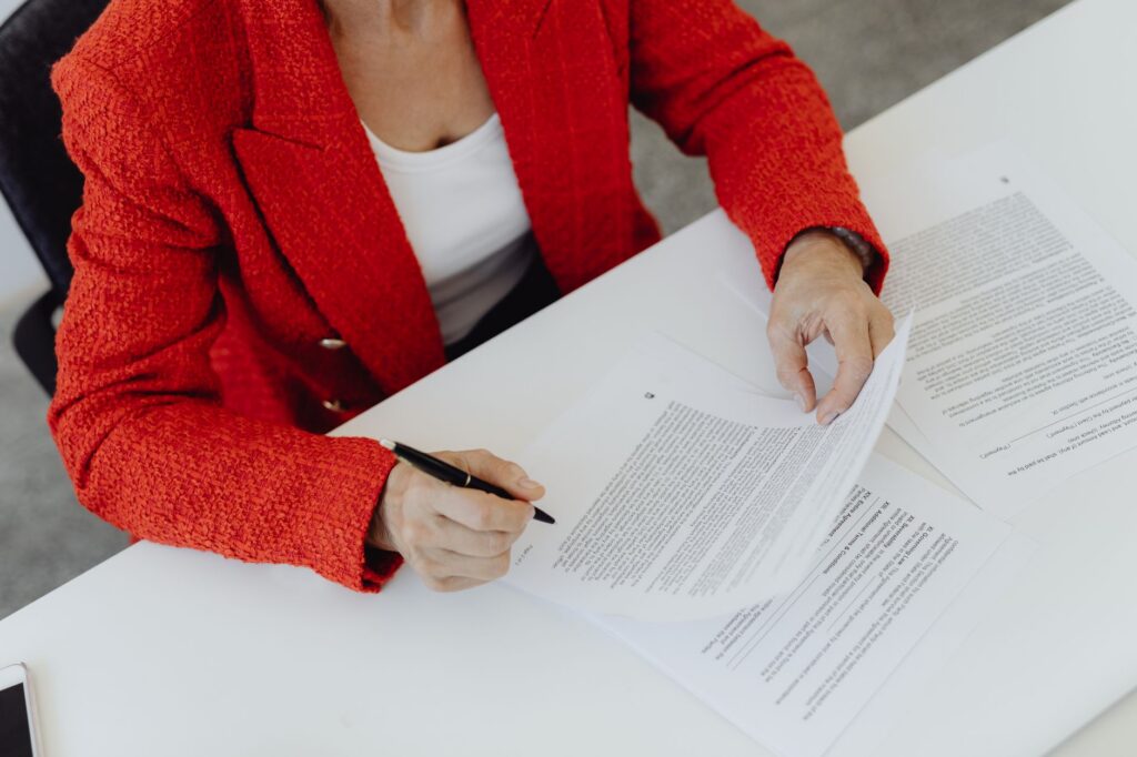 Confident business owner reviewing finalized settlement paperwork at a desk