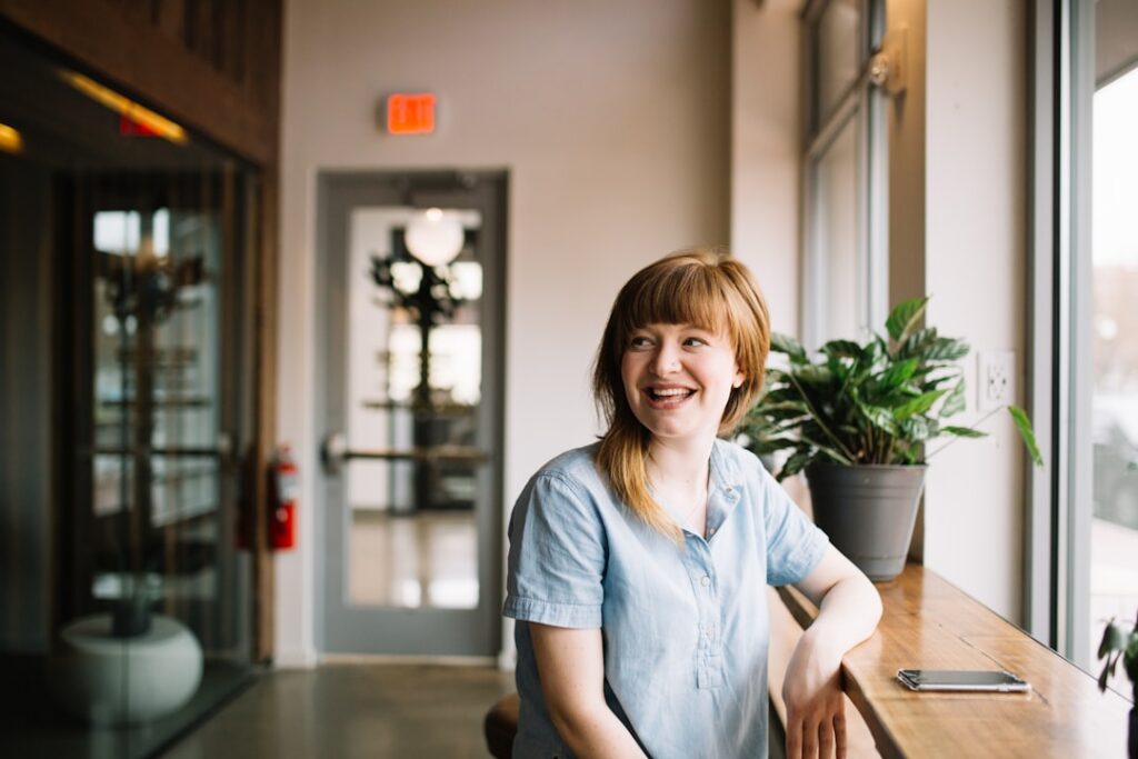 Relieved small business owner smiling behind the shop counter