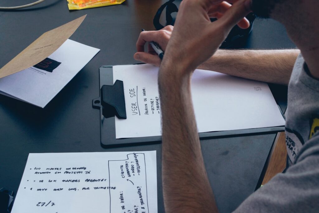 Hands reviewing UCC filing paperwork with a magnifying glass on a desk