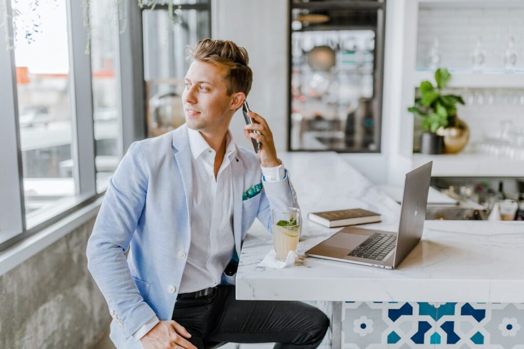 Small business owner on a phone call while reviewing bank statements at a desk