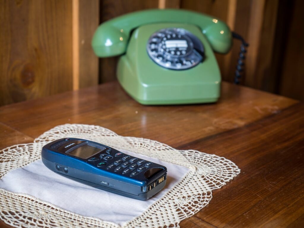 Office phone ringing repeatedly on a desk with an unfamiliar caller ID displayed