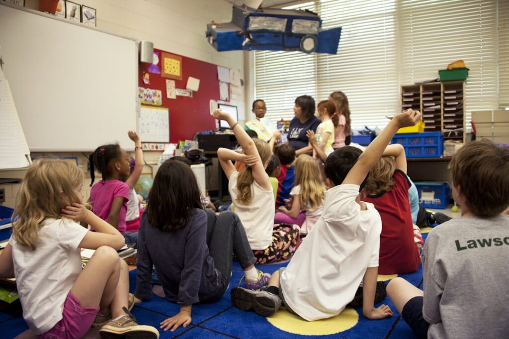 Daycare staff member supervising a small group of children in a classroom