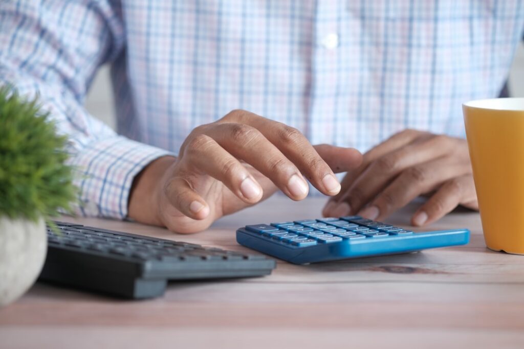 Business owner calculating MCA debt costs and holiday revenue projections