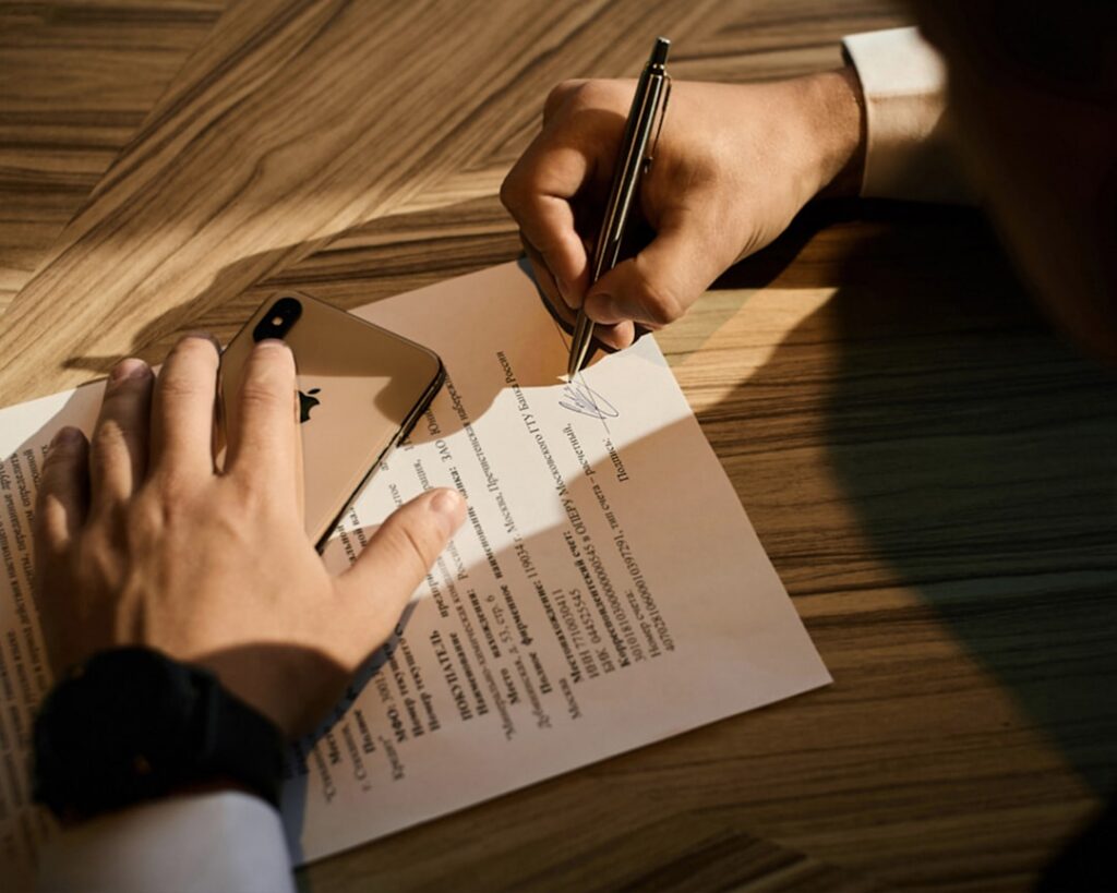 Small business owner reviewing and signing contract paperwork