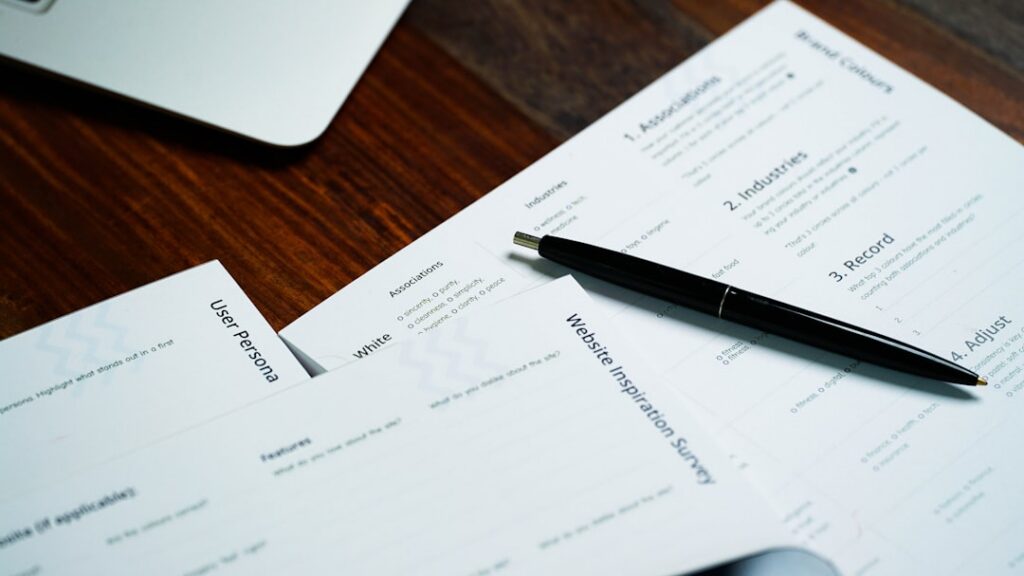 Two separate financing contracts placed side by side on a desk with a pen