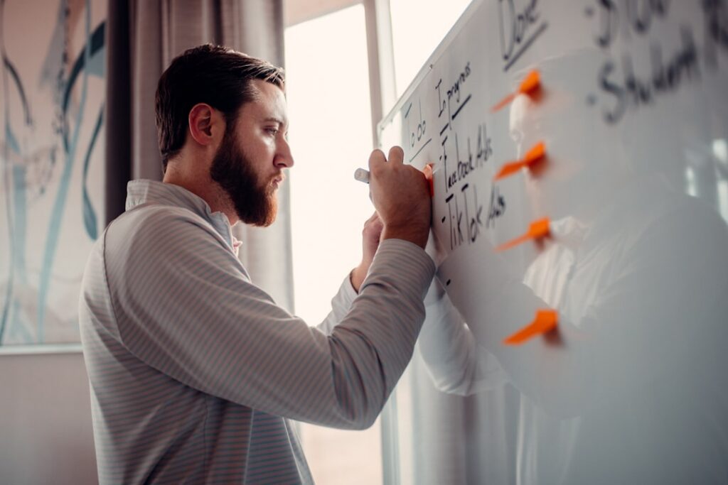 Business owner forecasting cash flow on a whiteboard with charts