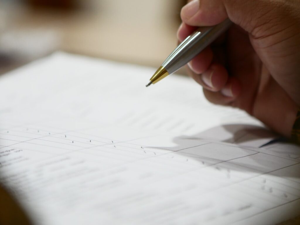 Close-up of a business financing contract with pen resting on the signature line
