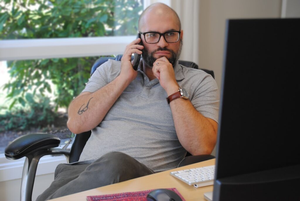 Small business owner on a phone call negotiating payment terms at a desk