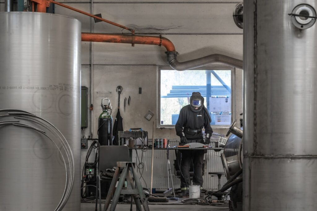 Brewery owner reviewing financial paperwork near stainless steel kegs