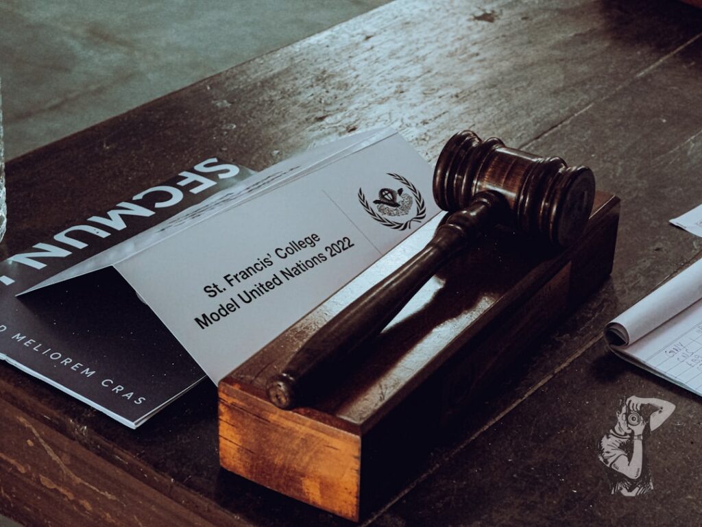 Close-up of a signed legal document next to a small gavel on a desk