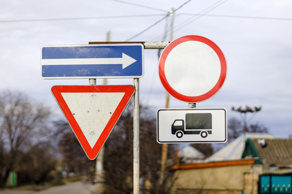 Three directional signs at a crossroads representing MCA debt options of forbearance, restructuring, and settlement